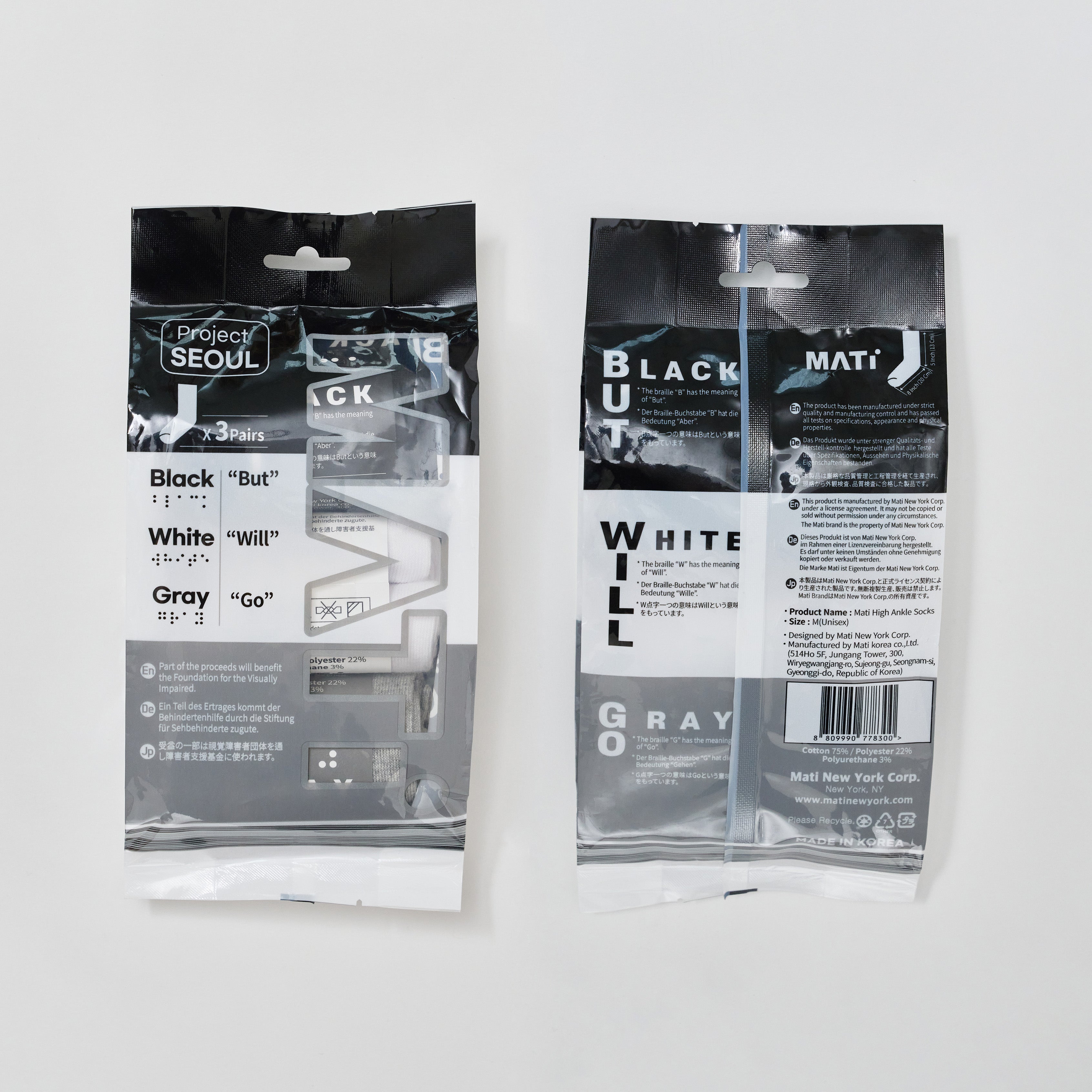 Product photography of Project Seoul and Mati New York Corp high ankle socks on a white background, featuring two black and white packages displaying braille alongside Black But White Will Gray Go, text about supporting the visually impaired, and visible black, white, and gray socks from Korea